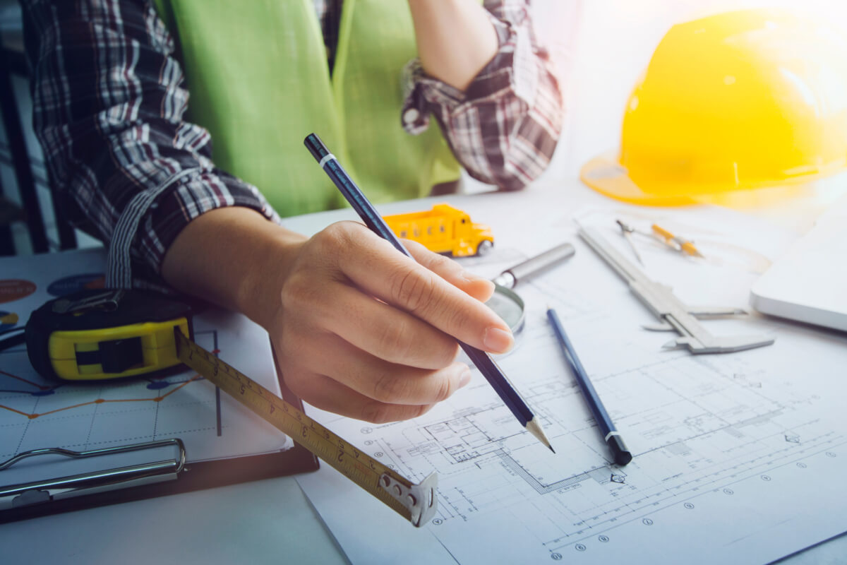 Engineer's hands working on blueprint.